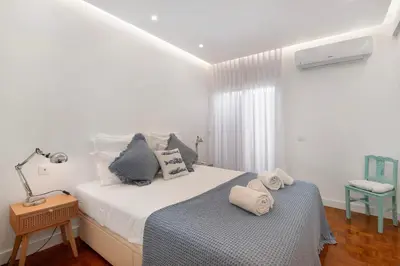 a bed with blue and white pillows on it at Luxury Sweet Homes T2 in Faro
