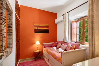a living room with orange walls and a couch at Country House Casa Da Avó in Loulé
