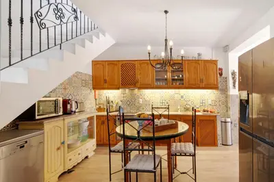 a kitchen with a table and chairs and a staircase at Country House Quinta da Ilda in Loulé