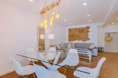 a dining room with a glass table and white chairs at Downtown Bingo Apartment in Faro