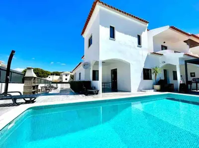 a villa with a swimming pool in front of a house at V8 Praia da Falésia, Albufeira in Olhos de Água