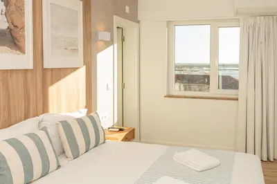 a bedroom with a bed with a view of the ocean at Faro Heart Suites in Faro