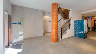 an orange column in a room with a staircase at Faro Heart Suites in Faro