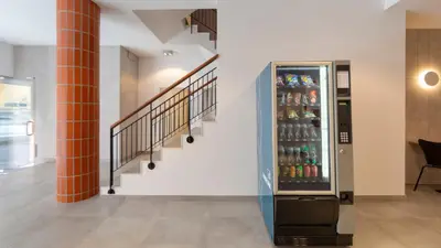 a hallway with a soda vending machine next to a staircase at Faro Heart Suites in Faro