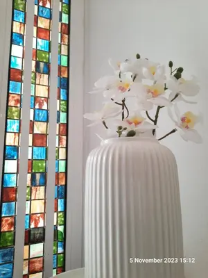 a white vase with a white flower in it at Blife Joanya private apartment in Faro