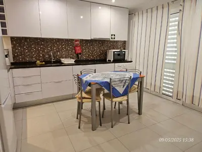 a kitchen with a table and chairs in a kitchen at Blife Joanya private apartment in Faro