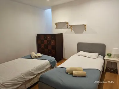a room with two beds and a chair in it at Blife Joanya private apartment in Faro