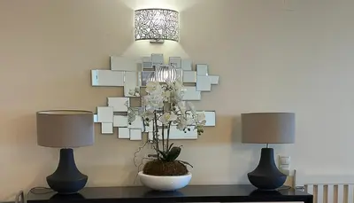 a table with two lamps and a chandelier on a wall at Vista Marina Exclusiva T1 HsR Vilamarina in Quarteira