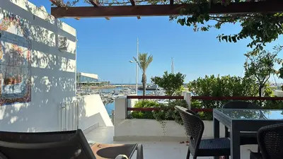 a patio with a table and chairs and a view of a marina at Vista Marina Exclusiva T1 HsR Vilamarina in Quarteira
