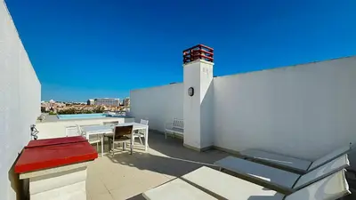 a balcony with a lighthouse and a table and chairs at Penthouse Triplex Marina T2 by HsR Vilamarina in Quarteira