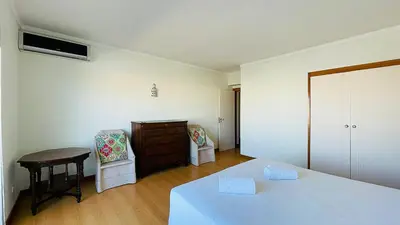 a bedroom with a bed and a table and chairs at Penthouse Triplex Marina T2 by HsR Vilamarina in Quarteira