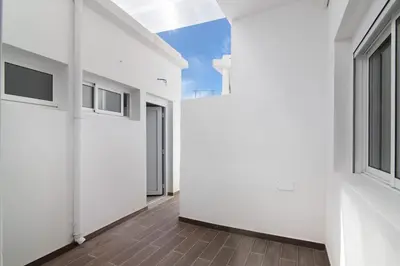 a bedroom with a white bed with two blue towels on it at Skipper House in Loulé