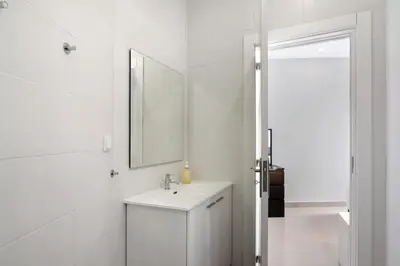 a white bathroom with a shower and a sink at Skipper House in Loulé