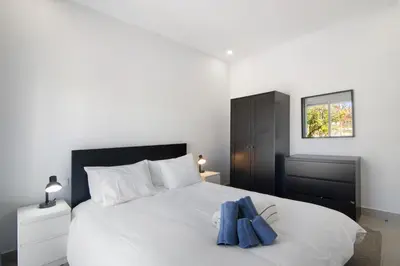 a bedroom with a white bed and a window at Skipper House in Loulé