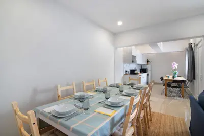 a living room with a table and a blue couch at Skipper House in Loulé