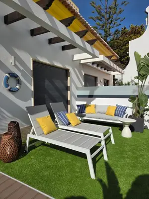 a patio with two benches on a lawn at Lotus by Check-in Portugal in Quarteira