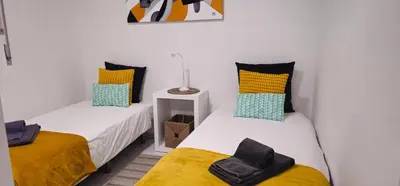 two beds in a room with yellow and blue pillows at Casa dos Sinos 2Bedroom Beach Apartment with Terrace in Albufeira