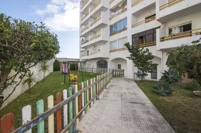 a building with a fence next to a sidewalk at Hilcity in Albufeira