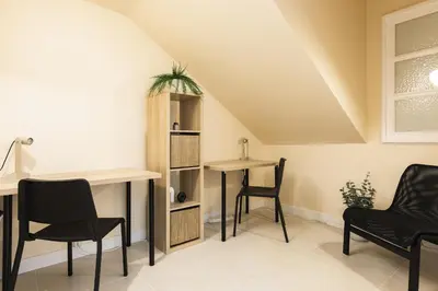 a room with chairs and a table and a desk at City Rooms Guest House by HD in Faro