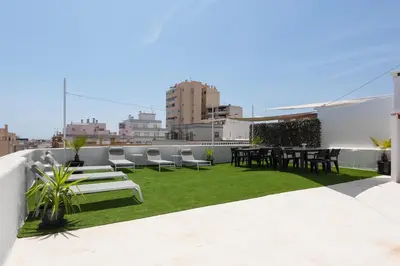 a patio with tables and chairs on a roof at City Rooms Guest House by HD in Faro