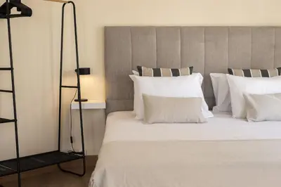 a bedroom with a large bed with white pillows at City Rooms Guest House by HD in Faro