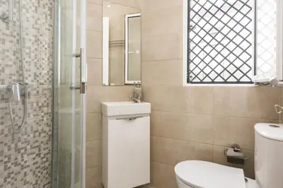 a bathroom with a toilet and a sink and a mirror at City Rooms Guest House by HD in Faro