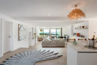 a kitchen and living room with a blue rug on the floor at Villa Oceânica in Albufeira