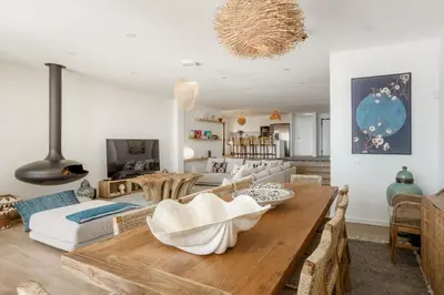 a living room with a wooden table and a dining room at Villa Oceânica in Albufeira