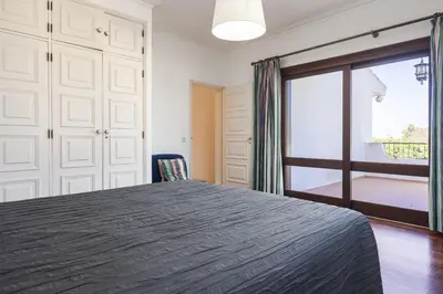 a bedroom with a bed and a sliding glass door at Vila Norte - Private Pool by HD PROPERTIES in Vilamoura