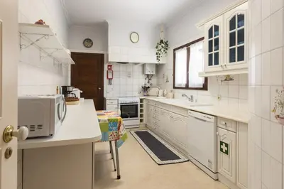a white kitchen with a sink and a microwave at Vila Norte - Private Pool by HD PROPERTIES in Vilamoura