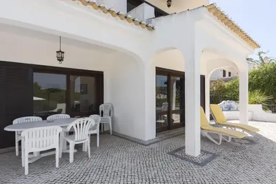 a white patio with white chairs and a table at Vila Norte - Private Pool by HD PROPERTIES in Vilamoura