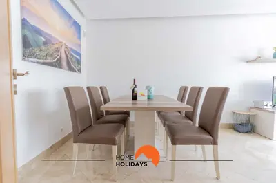 a dining room table and chairs with a painting on the wall at #228 Garrett Flats by Home Holidays in Albufeira