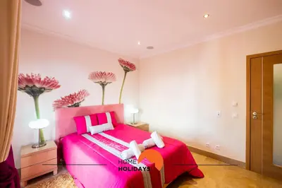 a pink bedroom with a pink bed and pink flowers at #228 Garrett Flats by Home Holidays in Albufeira