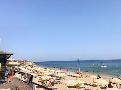 a beach with many umbrellas and people in the water at OURA WHITE VIEW Beach 2 min walk sea in Albufeira
