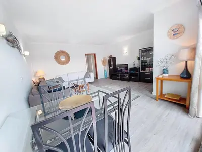 a living room with a table and chairs in a room at Silmaria Sea View amazing in Albufeira