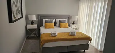 a bedroom with a large bed with yellow pillows at Faro Main Avenue Apartment II in Faro