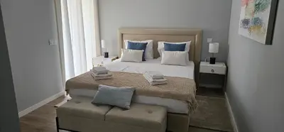 a bedroom with a large bed with blue and white pillows at Faro Main Avenue Apartment II in Faro