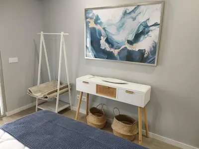 a bedroom with a white table and a painting on the wall at Faro Main Avenue Apartment II in Faro