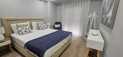 a white bedroom with a bed and a window at Faro Main Avenue Apartment II in Faro