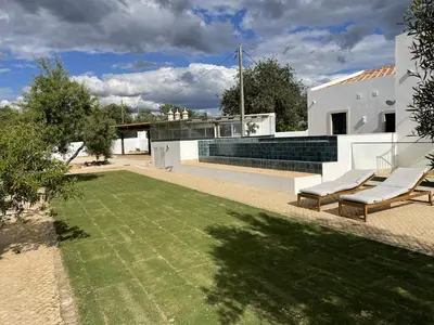 a view of the backyard of a house with a lawn at Monte Gerações - Heated pool - Typical Algarvian - close to Quinta Lago, Vale Lobo and Vilamoura in Almancil