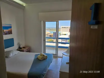 a bedroom with a bed and a view of a balcony at Blife Ceriya private apartment in Faro