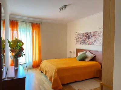 a bedroom with an orange bed and a window at Vilamoura TOP MouraPraia in Vilamoura