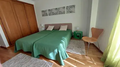 a bedroom with a green bed with a green blanket at Vilamoura TOP MouraPraia in Vilamoura