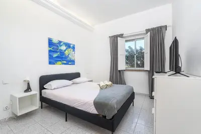 a bedroom with a bed and a flat screen tv at Blife Riamya private apartment in Faro
