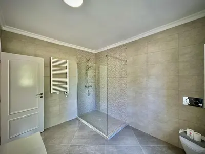 a bathroom with a shower with a glass door at Quarteira Premium Villa With Pool by Homing in Quarteira