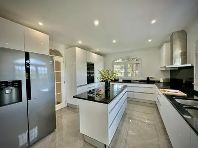 a kitchen with white cabinets and a black counter top at Quarteira Premium Villa With Pool by Homing in Quarteira