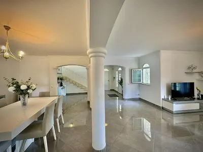 a dining room and living room with a pillar at Quarteira Premium Villa With Pool by Homing in Quarteira