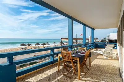 a balcony with a table and chairs and the beach at Blife Vistaya private apartment in Faro