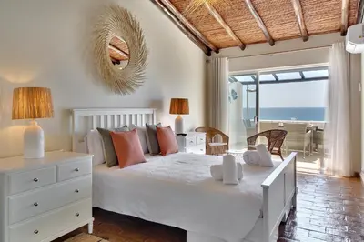 a bedroom with a white bed with a view of the ocean at Beach Residence Old Town in Albufeira