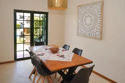a dining room with a wooden table and chairs at Casa Santos in Albufeira
